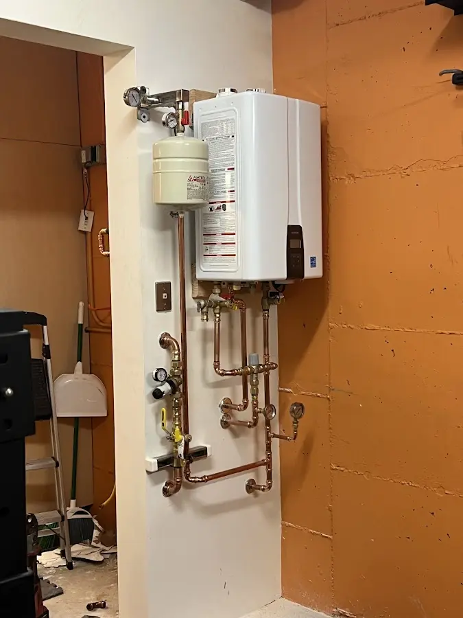 Plumbing technician inspecting water heater connections in Galion
